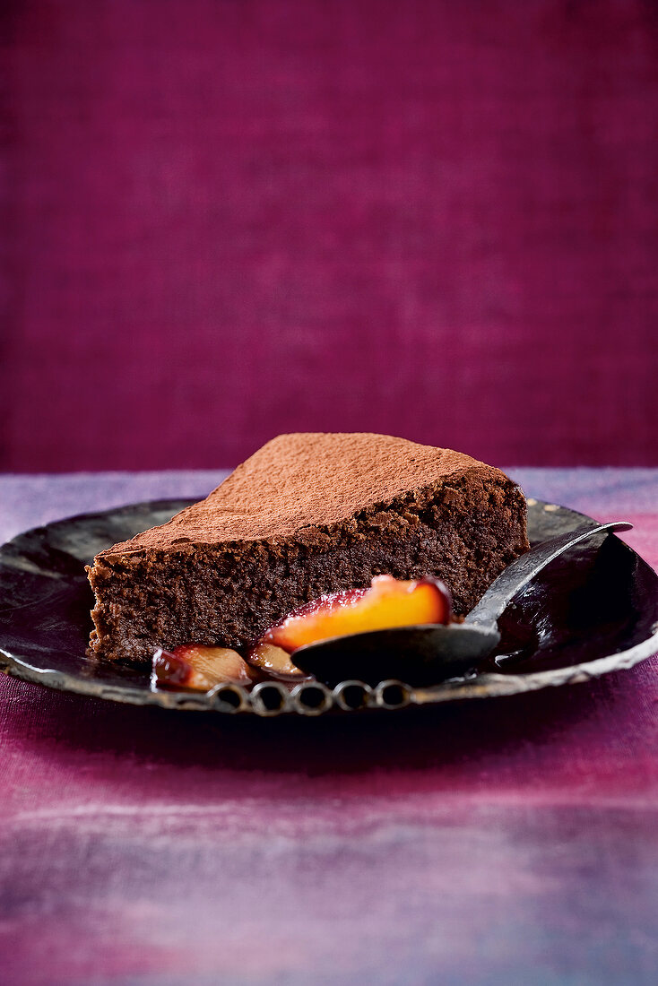 Compote chocolate cake with spicy plum on ceramic plate