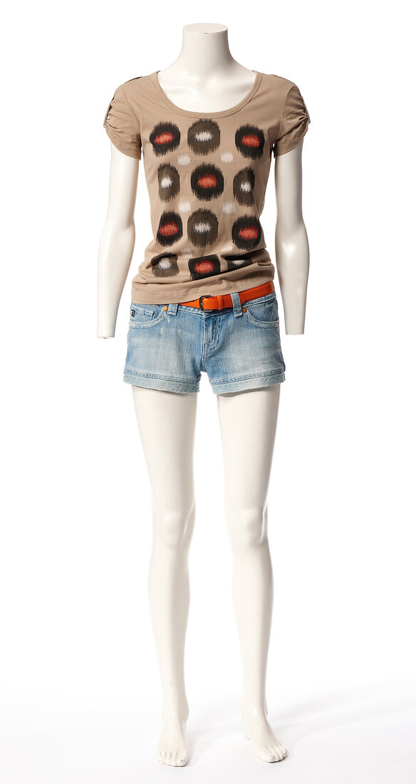 Ethno print shirt, short jeans and red belt on mannequin against white background