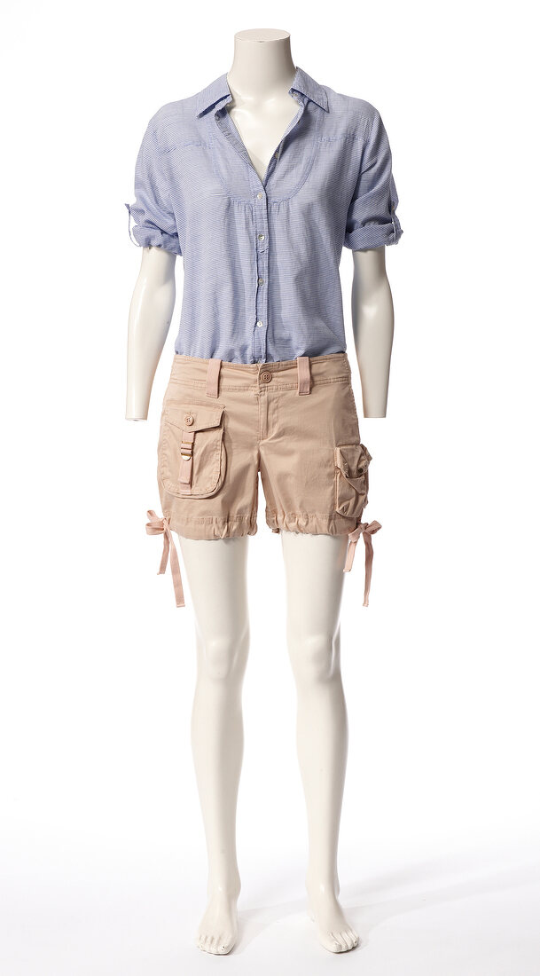 Blue short sleeved shirt and beige shorts on mannequin against white background