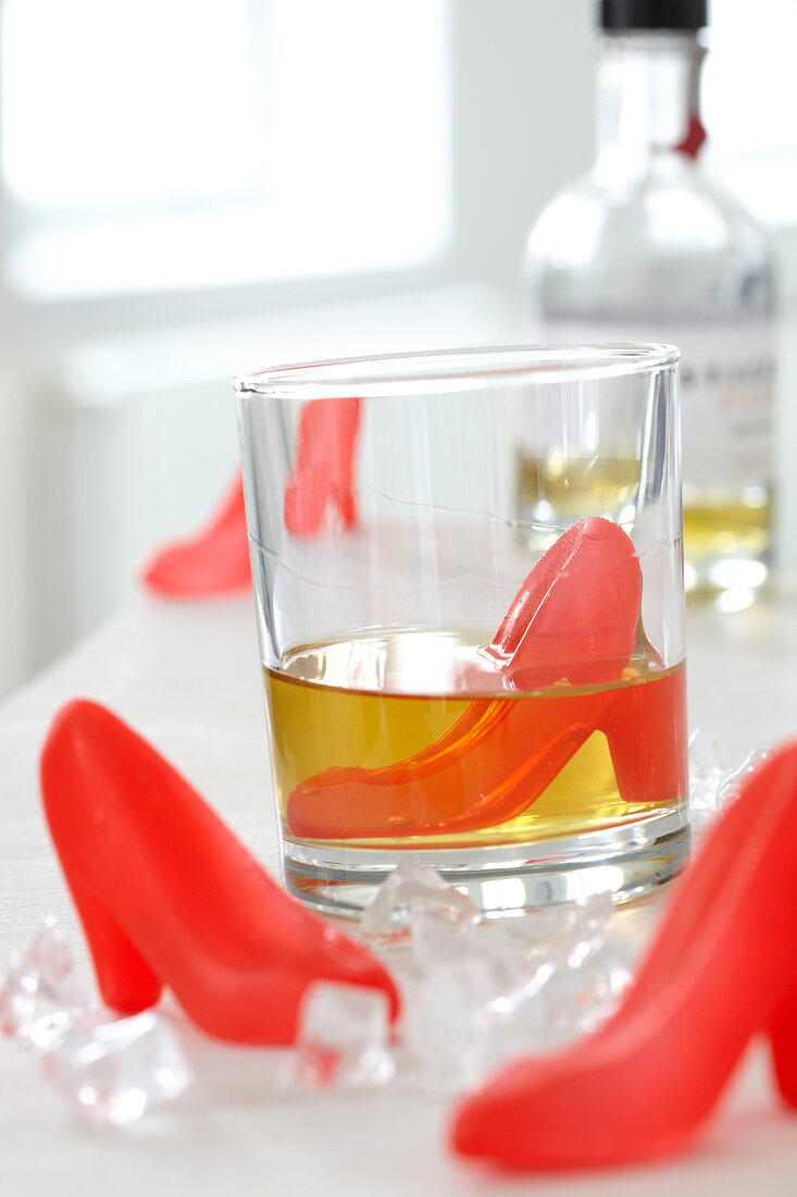 Ice cubes shaped as red pumps in a drink