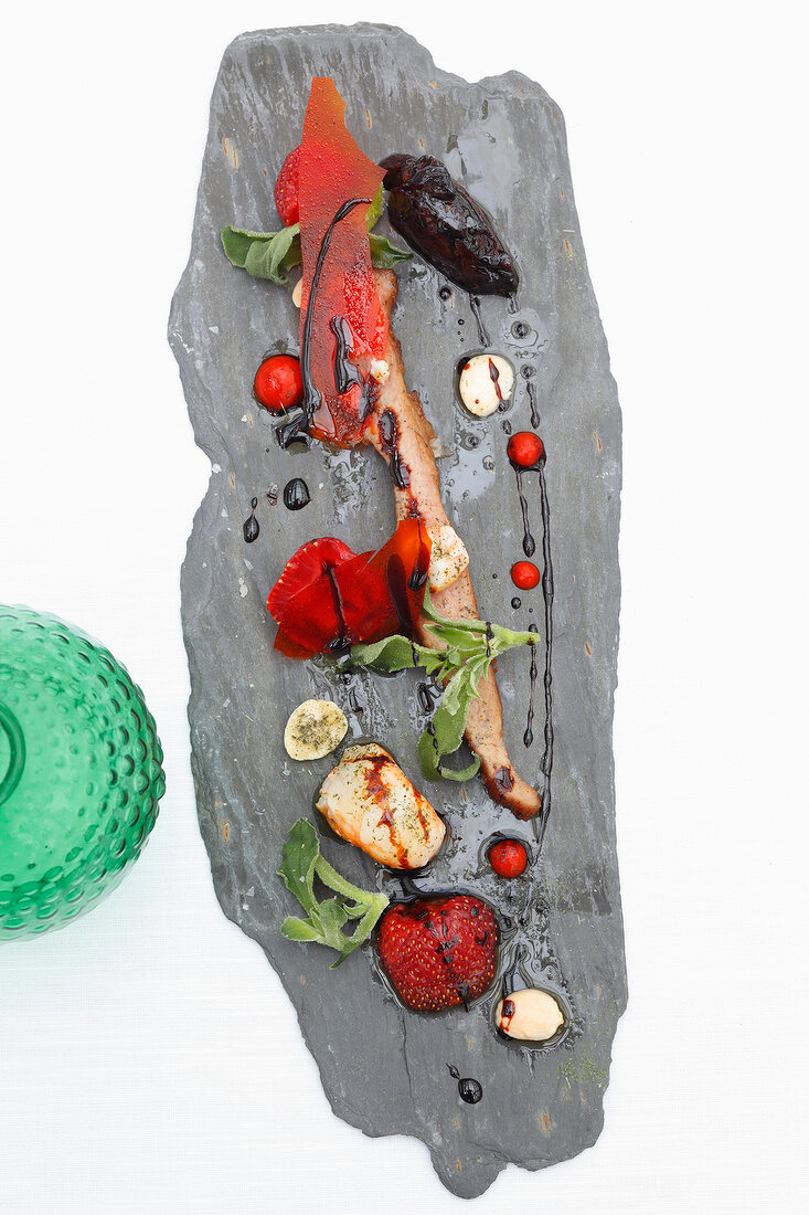 Potpourri of strawberries, Iberian ham and langoustine on white surface, overhead view