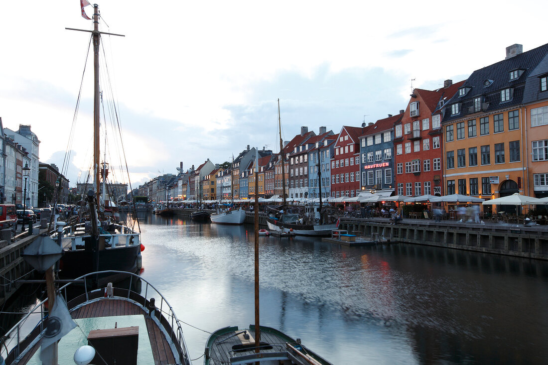 View of colourful buildings along with boats in Nyhavn at dusk, Copenhagen, Denmark
