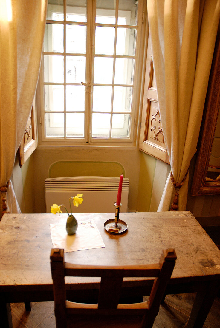 Table and chair in front of window in room of hotel Palazzo Gamboni, Ticino, Switzerland