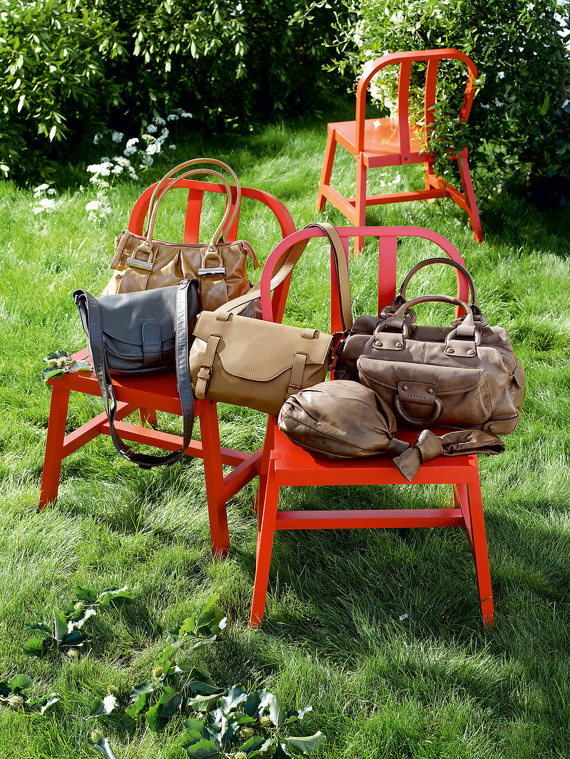 diverse Handtaschen, Stühle rot, Wiese