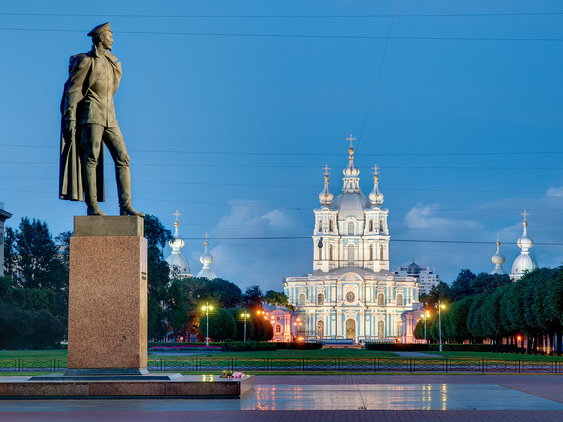 Monument in front of illuminated Smolny Cathedral at night in St. Petersburg, Russia