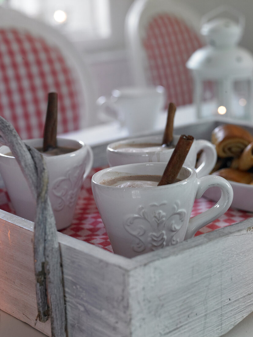 Cocoa in coffee mugs with cinnamon sticks