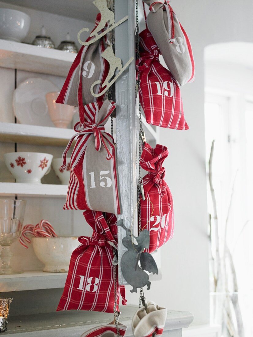 Red and white advent calendar sacks handing on a metal chain