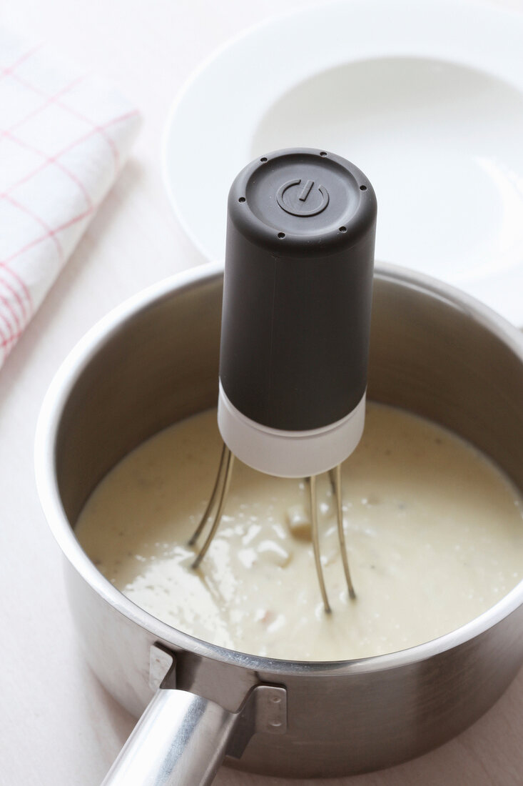 Close-up of electric stirrer in sauce pan