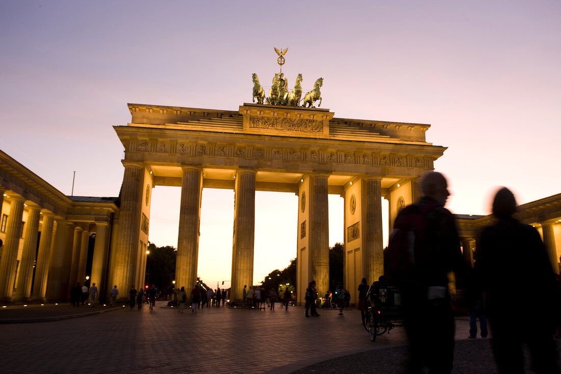 Berlin: Pariser Platz, Brandenburger Tor, abends, Menschen, unscharf.