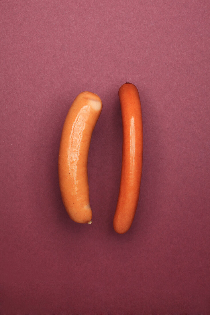 Sausage and frankfurters on maroon background