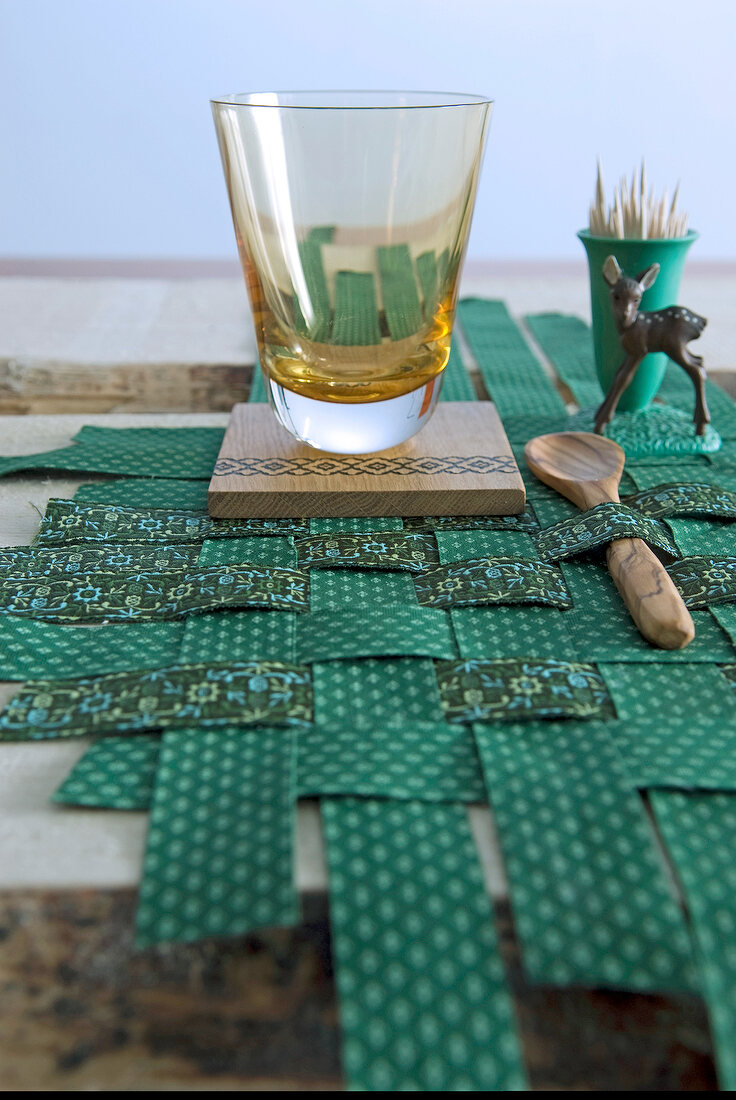 Close-up table with green tablecloth and glass on wooden tray