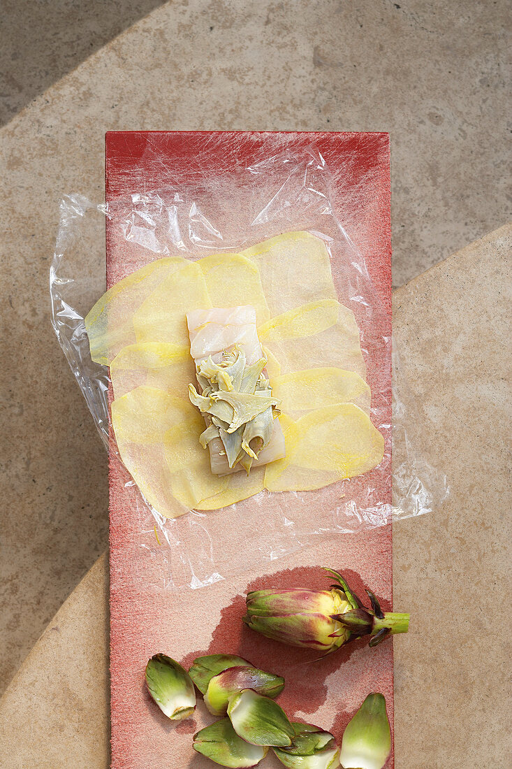 Loup de Mer, Step: Filet auf Kartof- felscheiben legen, Artischocke
