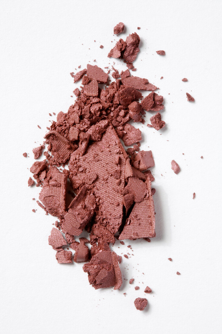 Close-up of eye make-up shadow and powder crumbled on white background