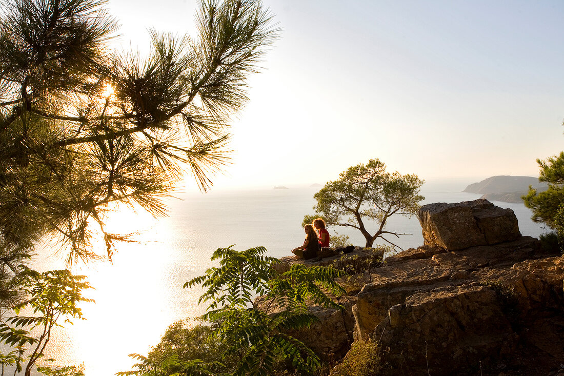 Couple sitting on cliff in front of Marmara sea, Prince island, Istanbul, Turkey