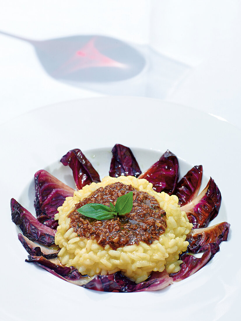 Bowl of risotto with duck liver, Bolognese and red chicory on plate