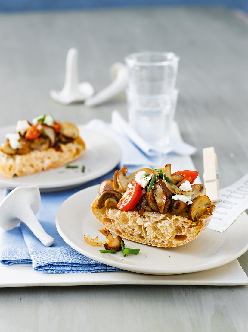 Ciabatta with mushrooms, cherry tomatoes and feta cheese on plates