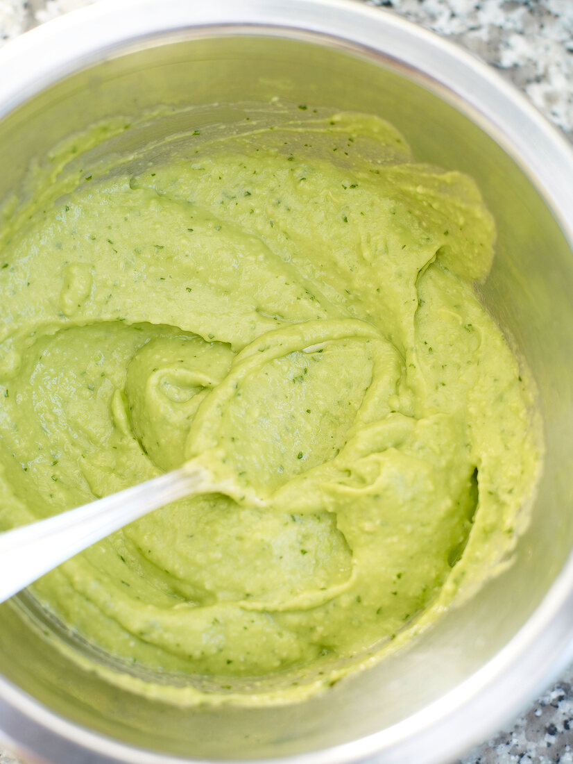 Close-up of avocado cream in bowl with spoon in it