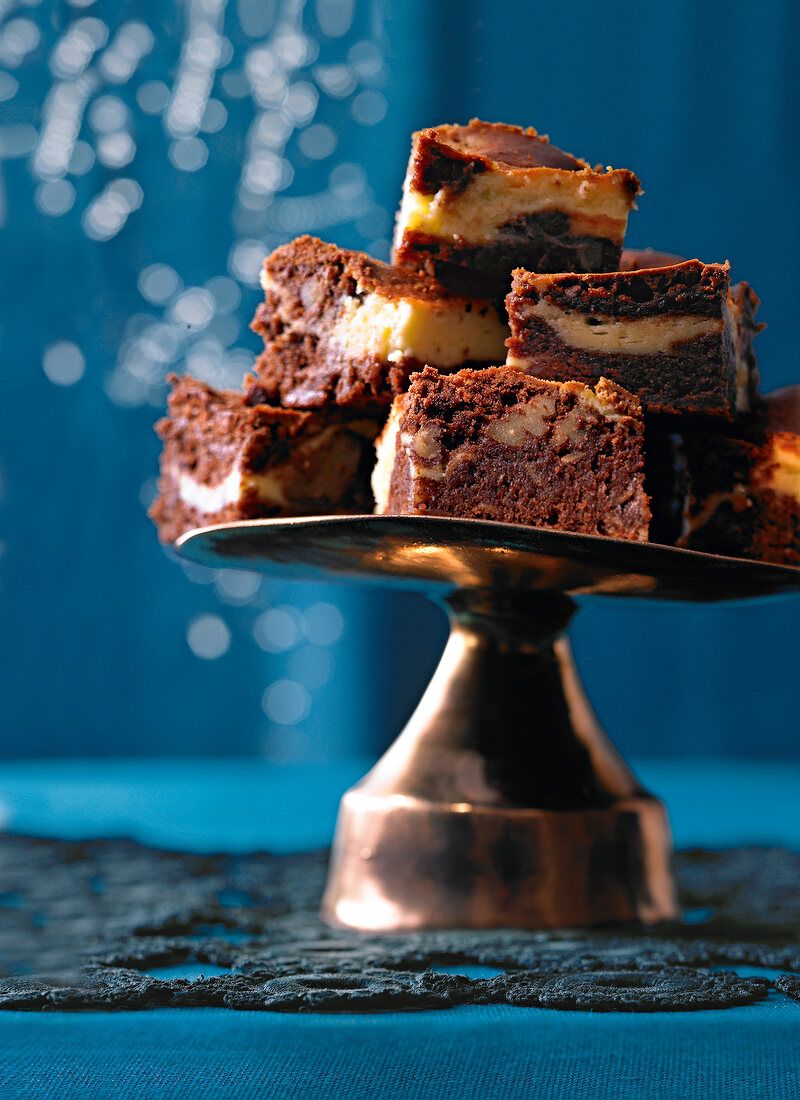 Stack of marble brownies with pecans on cake stand