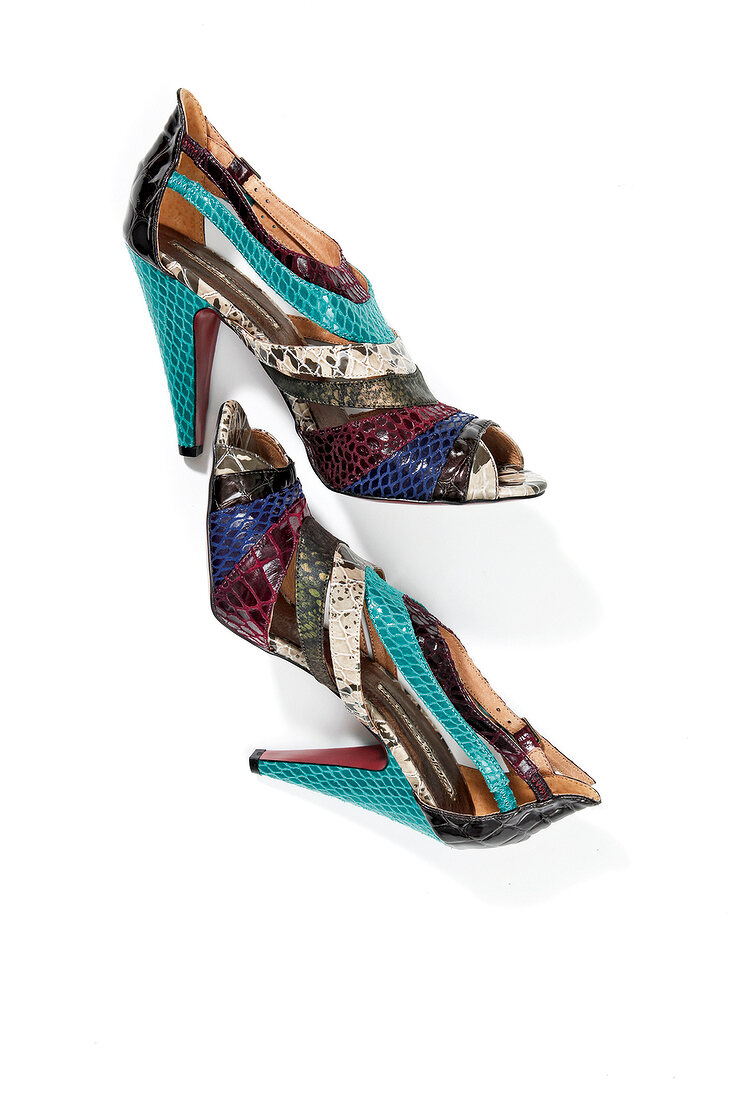 Close-up of brown and turquoise high heels with reptile skin on white background