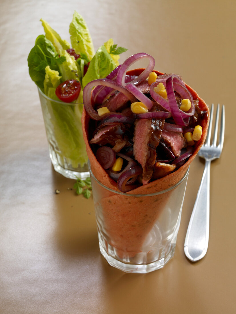 Close-up of wraps with steak in whiskey marinade in glass