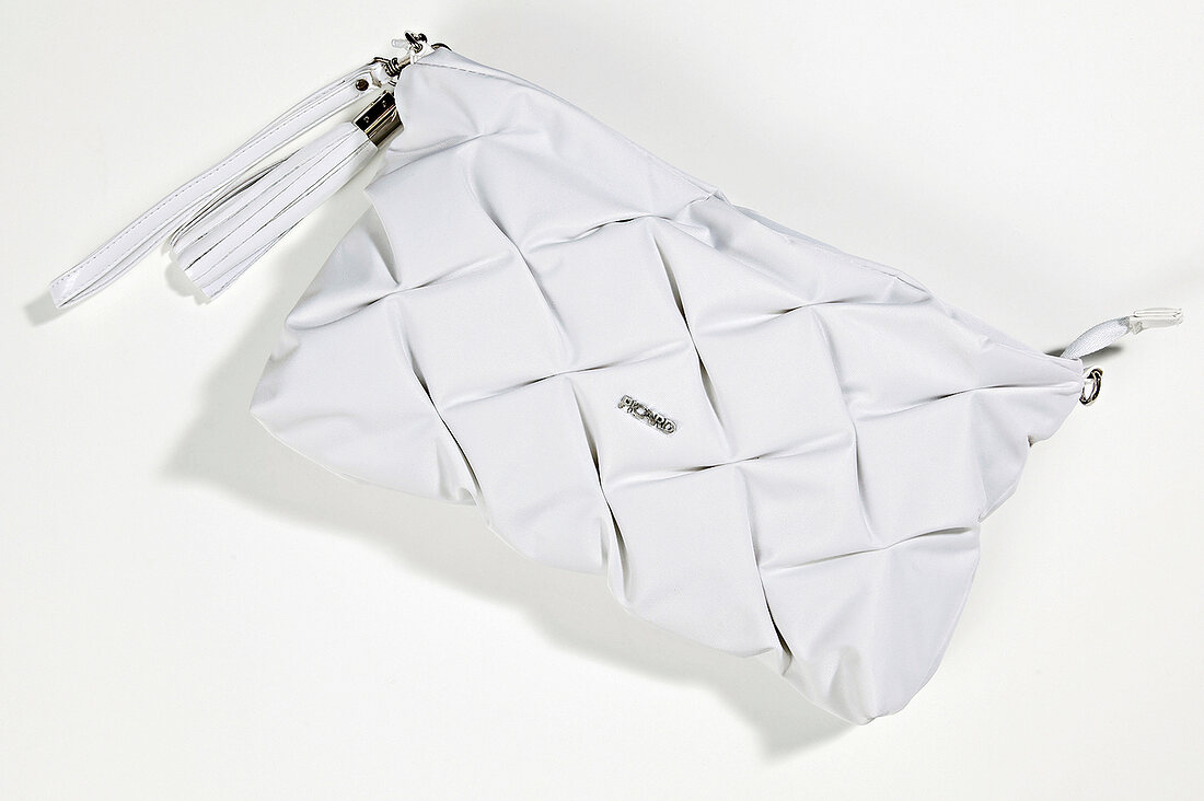 Close-up of white quilted handbag on white background