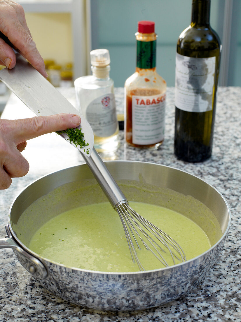 Close-up of man's hands adding ingredients in pan