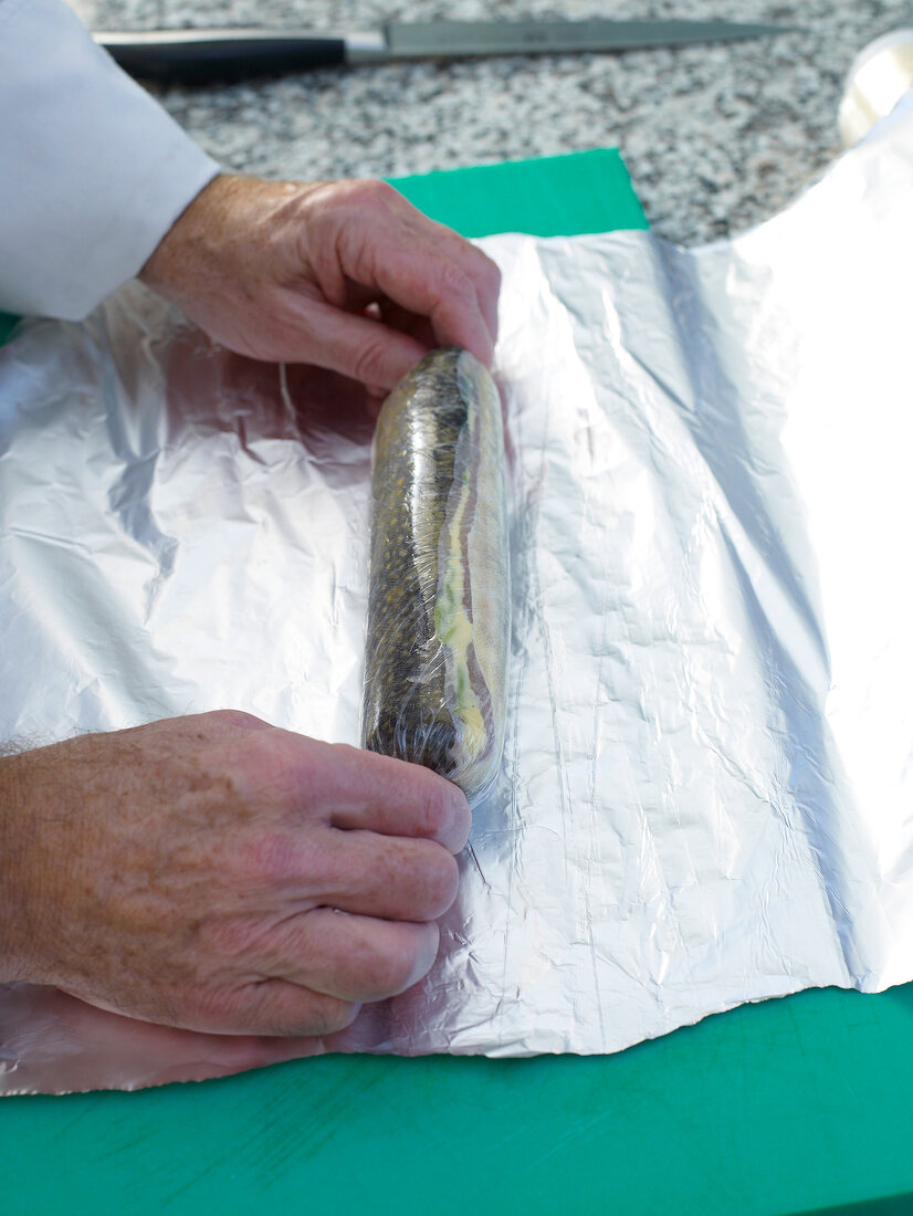 Arctic char being wrapped in silver foil