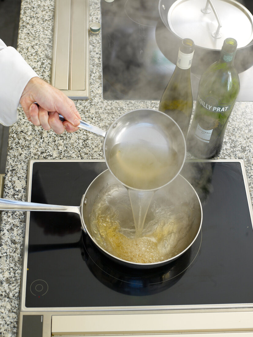 White wine sauce being poured in pan