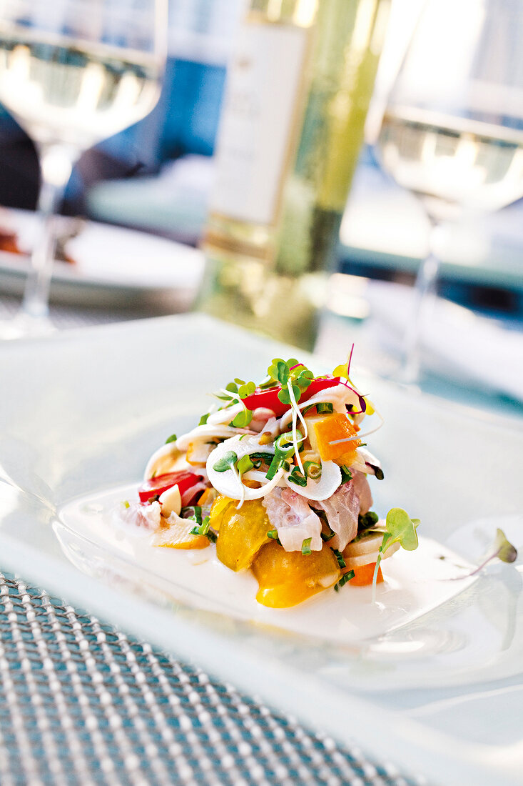 Peruvian Tiradito made of snapper, palm hearts, leeks and watercress on plate