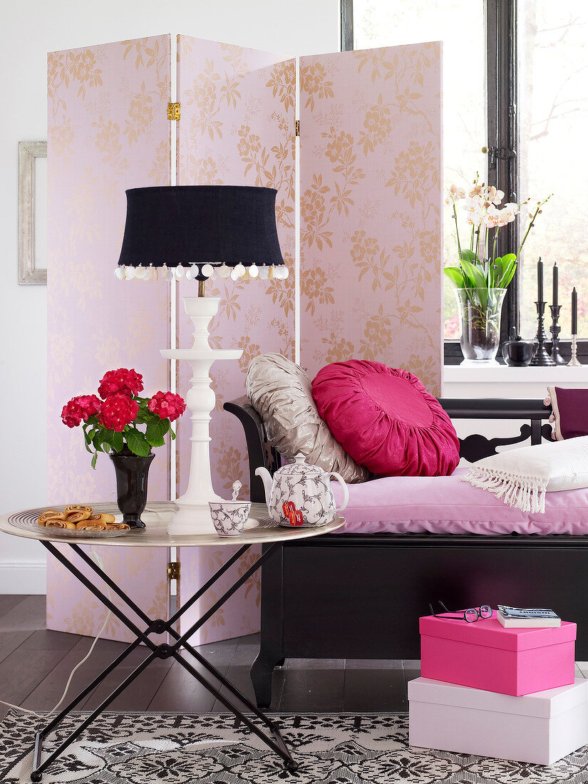 Tray table, pink folding partition and bench with cushions in living room