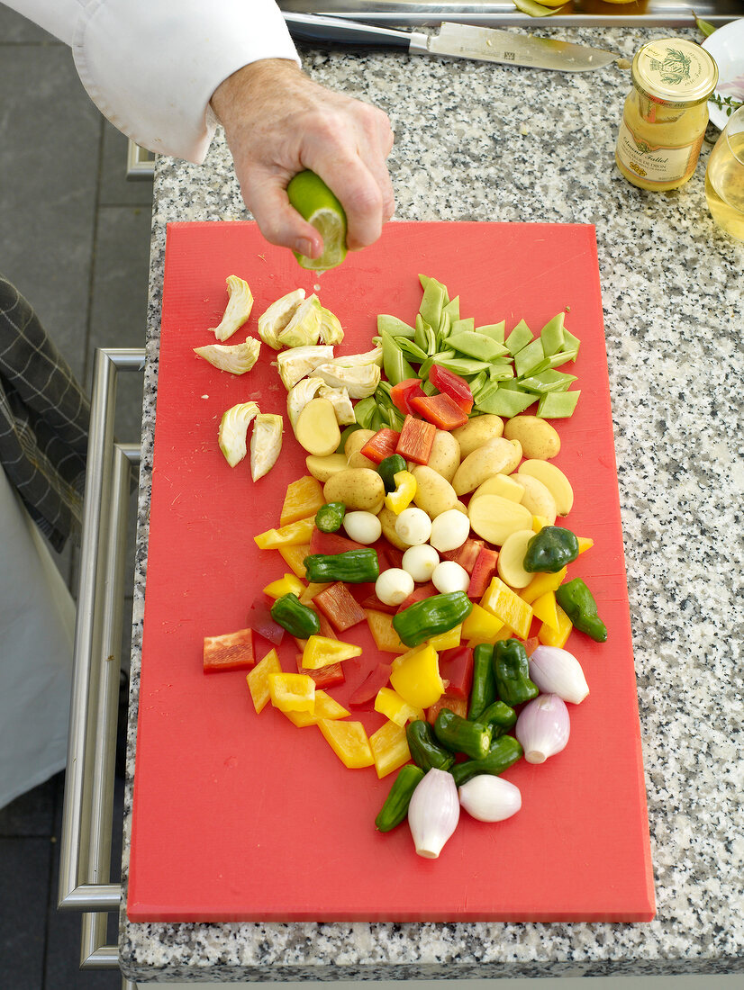 Lime being squeezed on chopped vegetables