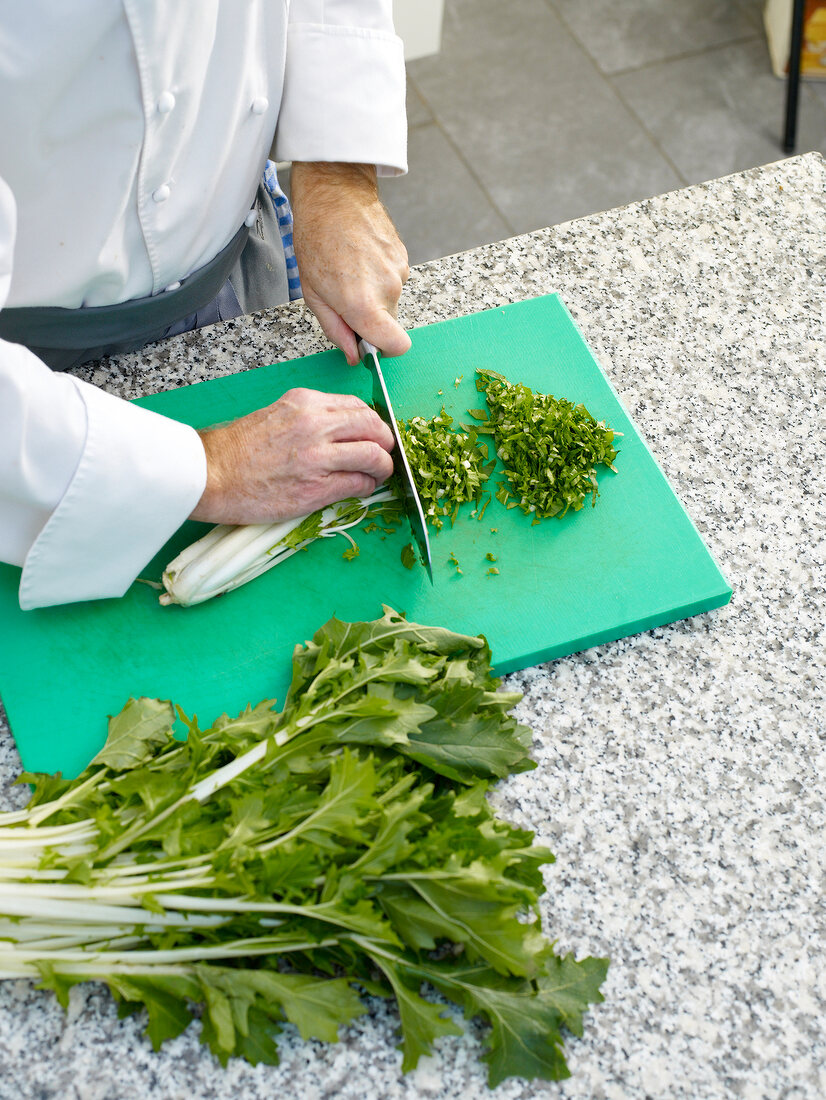 Chopping turnip green with knife