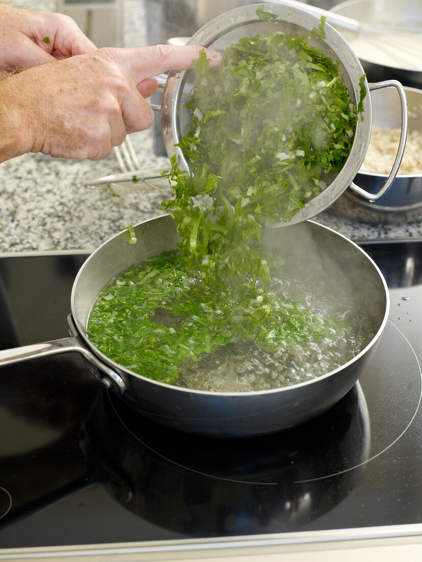 Chopped turnip green being added in boiling water