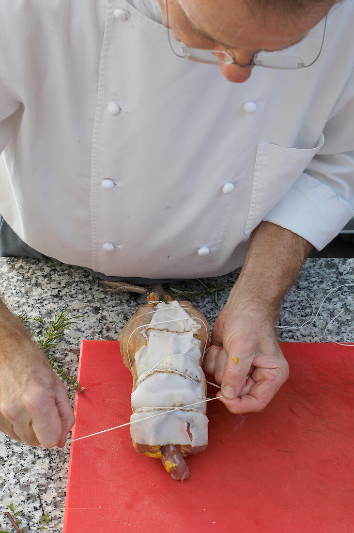 Tying covered stuffed pheasant with thread