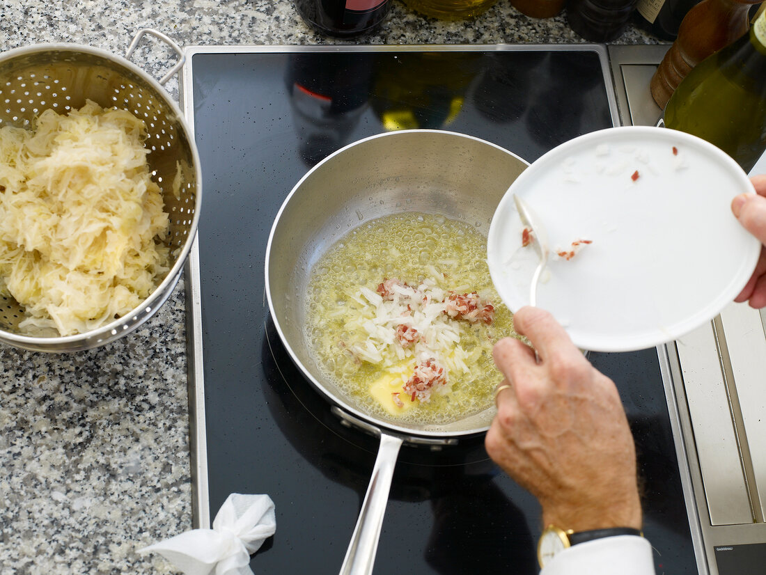 Putting sauerkraut in saucepan