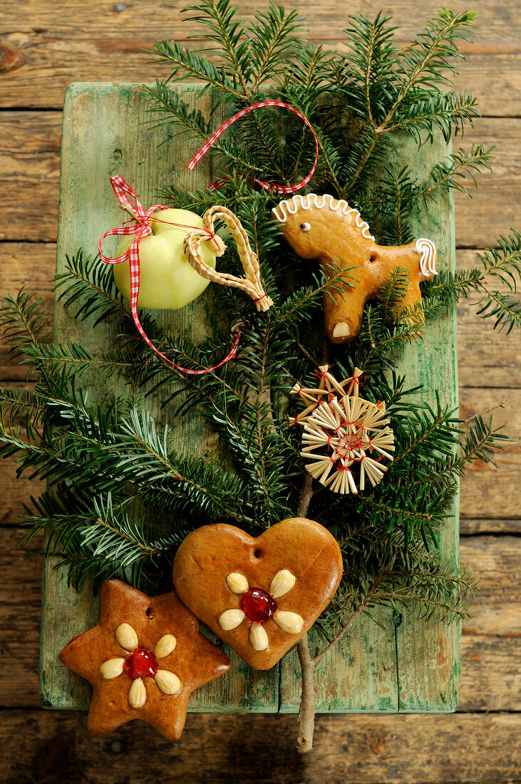 Green pine, gingerbread and flower arrangement on wooden table for Christmas decoration
