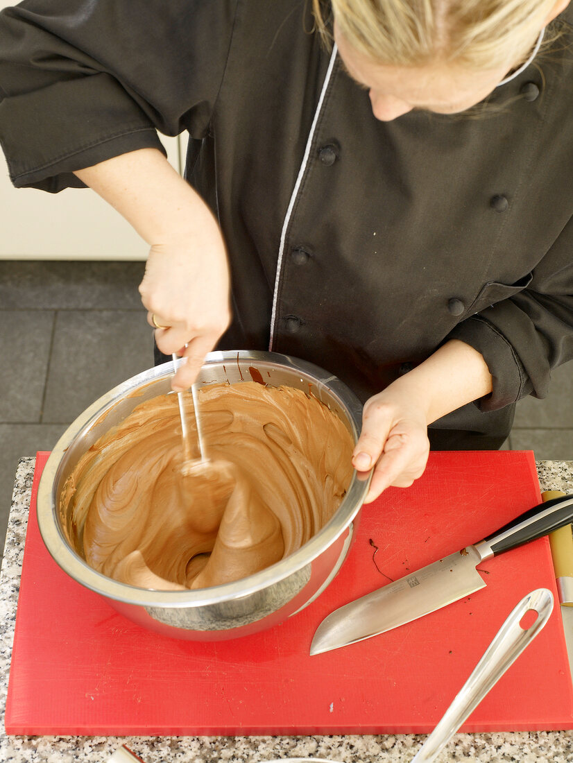 Whisking chocolate with cream in bowl