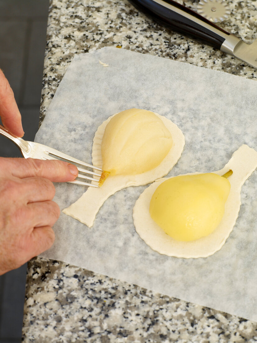 Making design on puff pastry with fork