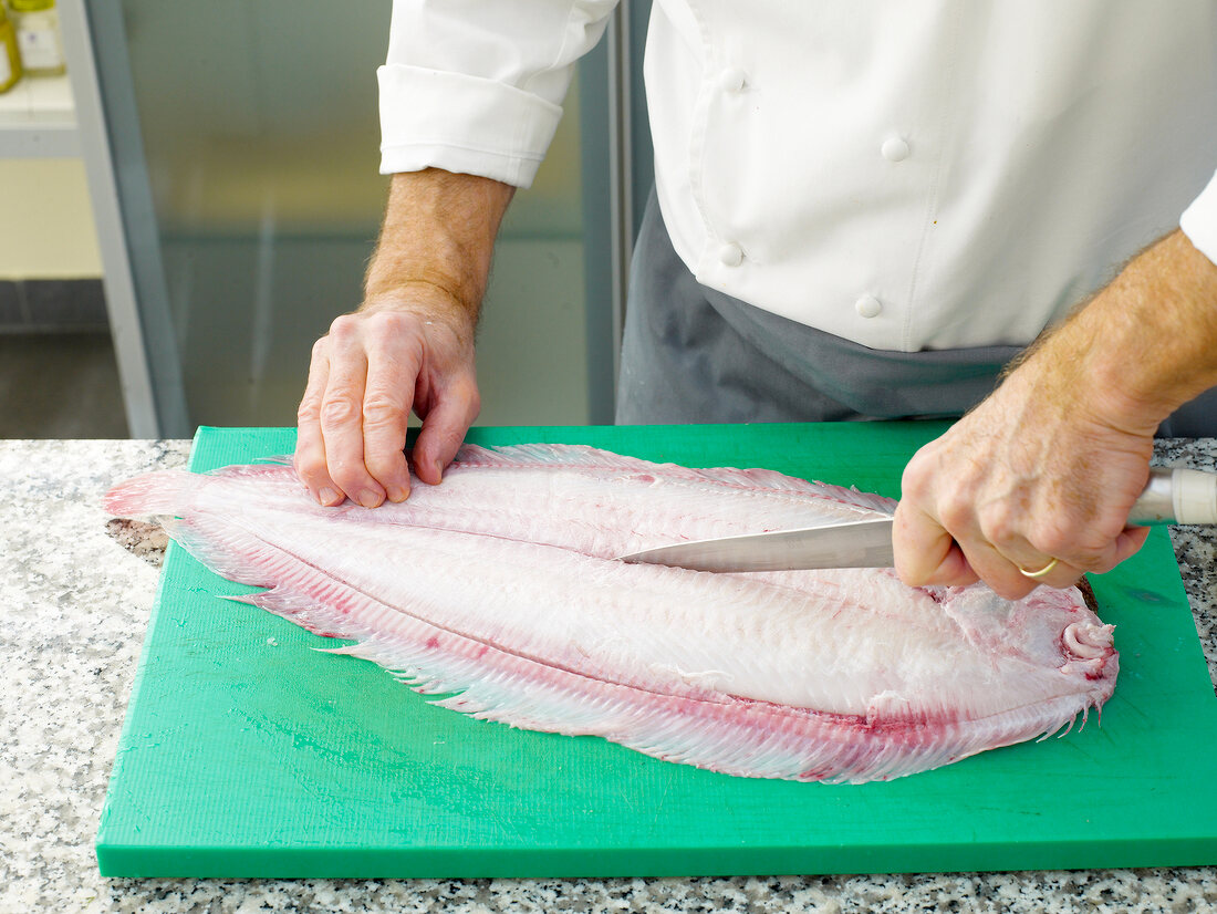 Filleting sole by hand on chopping board