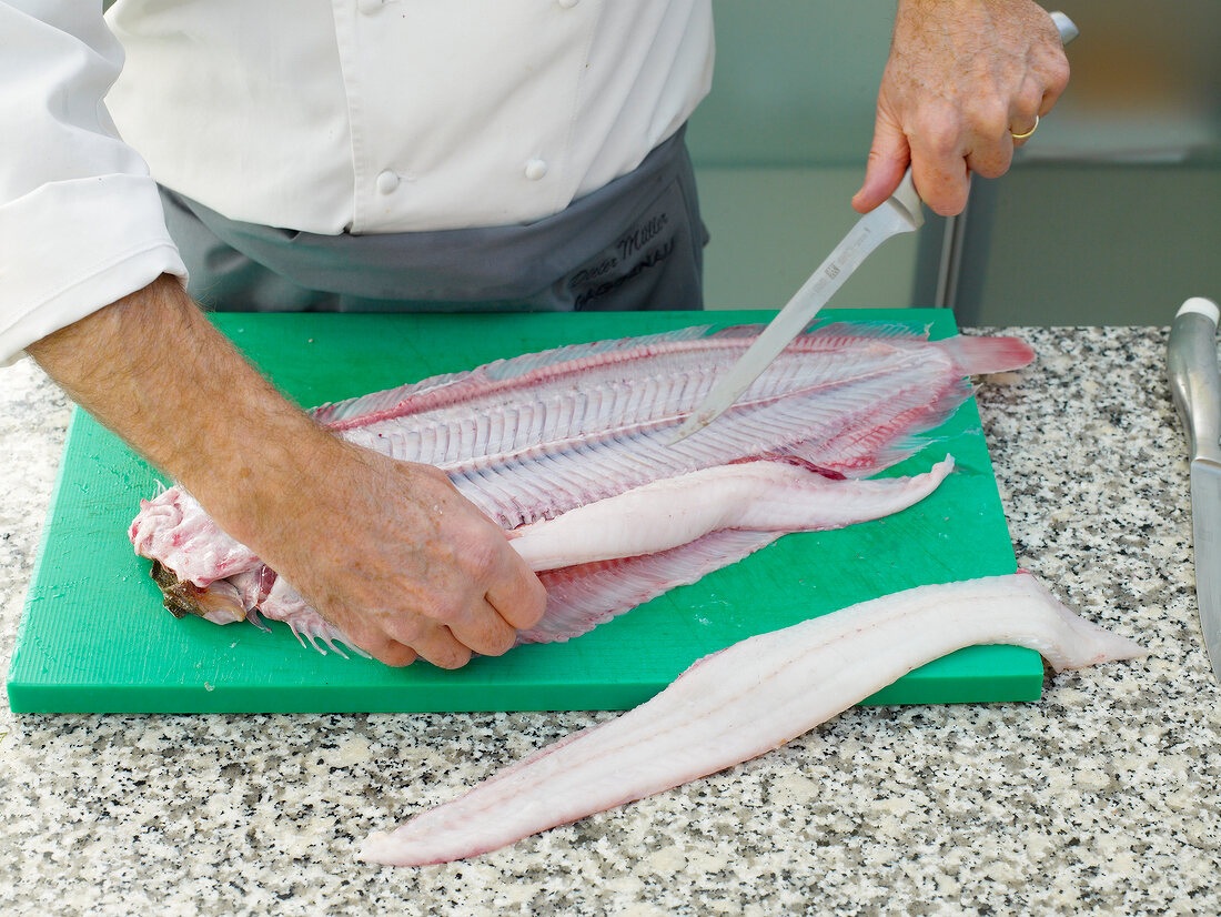 Filleting sole by hand on chopping board