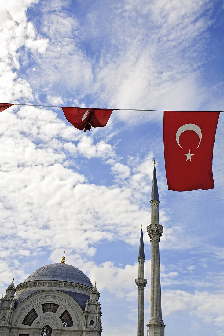 View of dome of mosque, minarets, clouds and Turkish flag