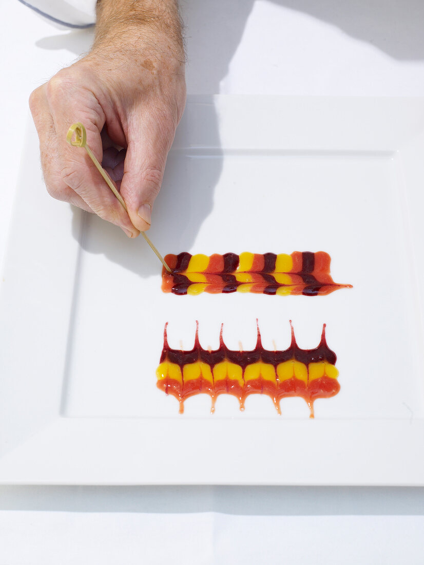 Plate being decorated with different type of fruit sauces