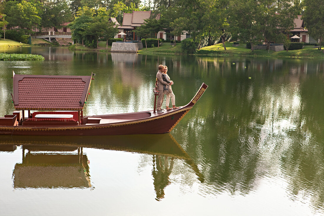Romantic couple embracing and standing in boat at a lake in Parkland