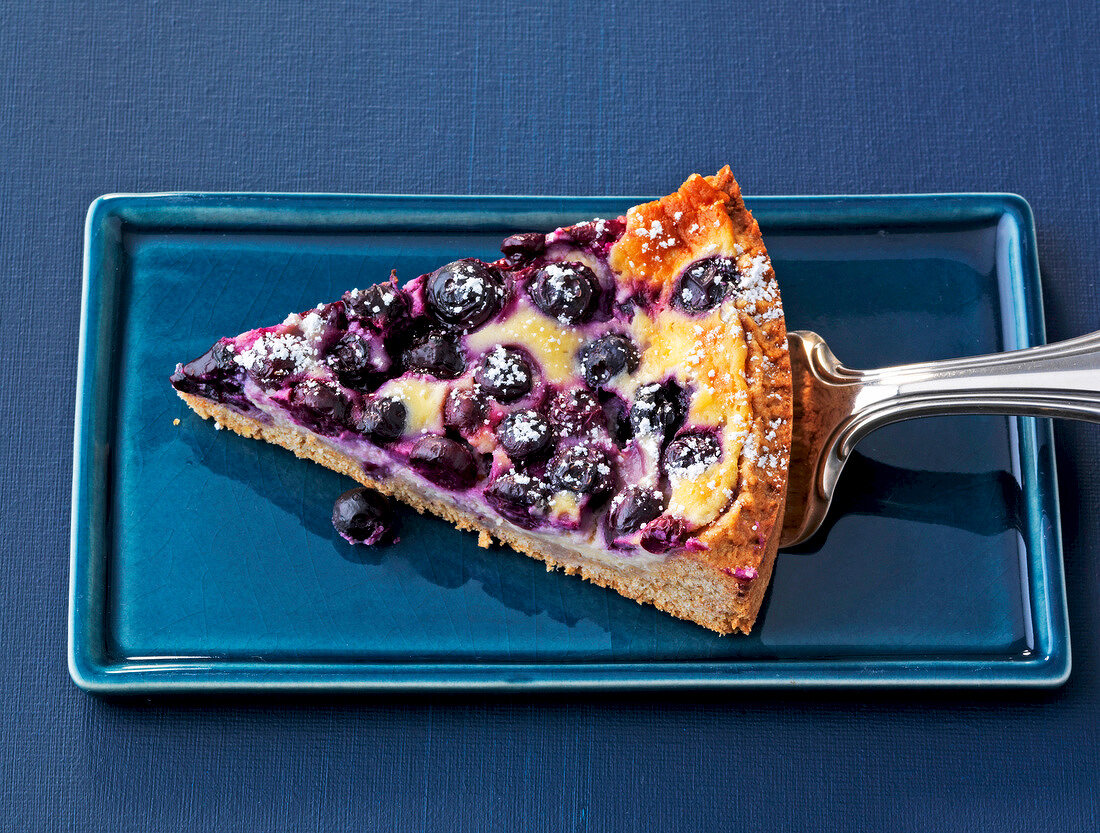 Piece of blueberry mascarpone cake on plate