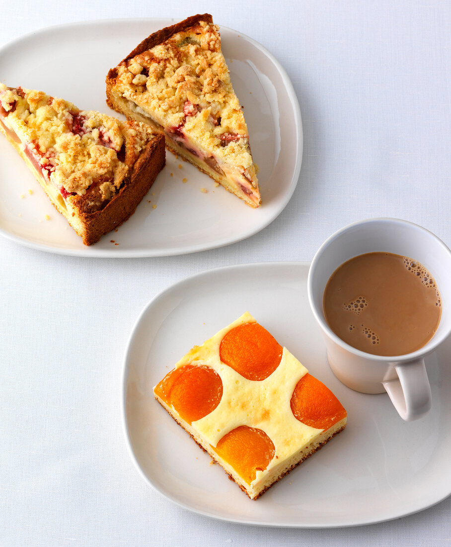 Rhubarb cake and apricot cakes with cup of coffee on plate