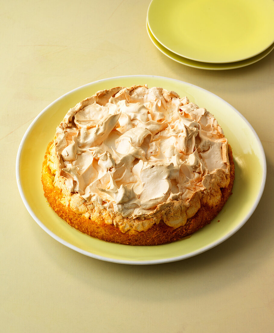 Gooseberry meringue pie with cream on plate