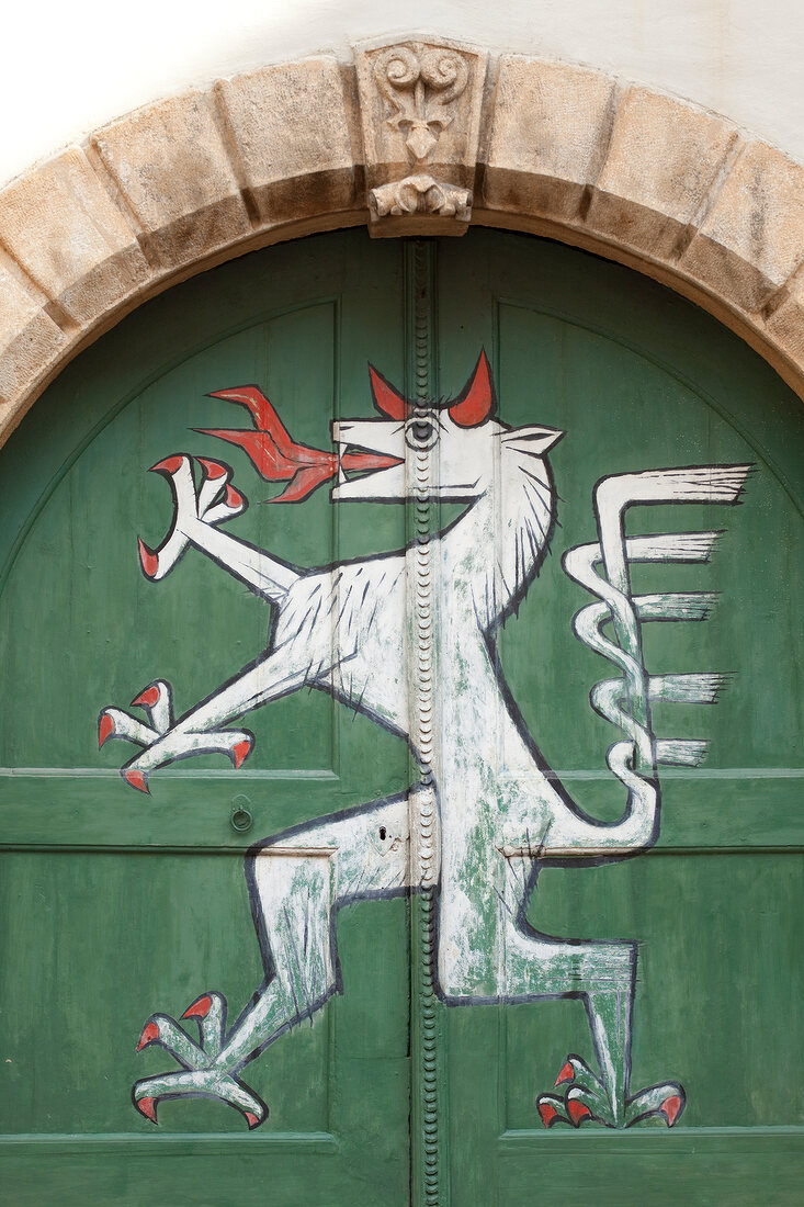 Close-up of archway and painting of dragon on green gate in Styria, Austria