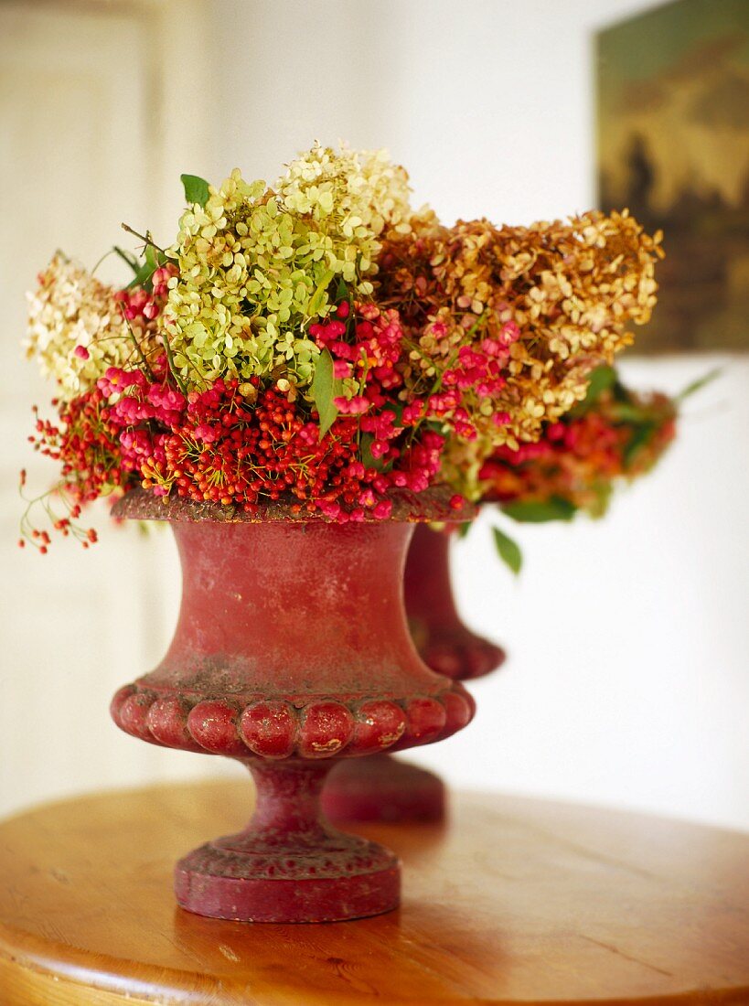 Bouquets of dried hydrangeas and spindles in stoneware vases