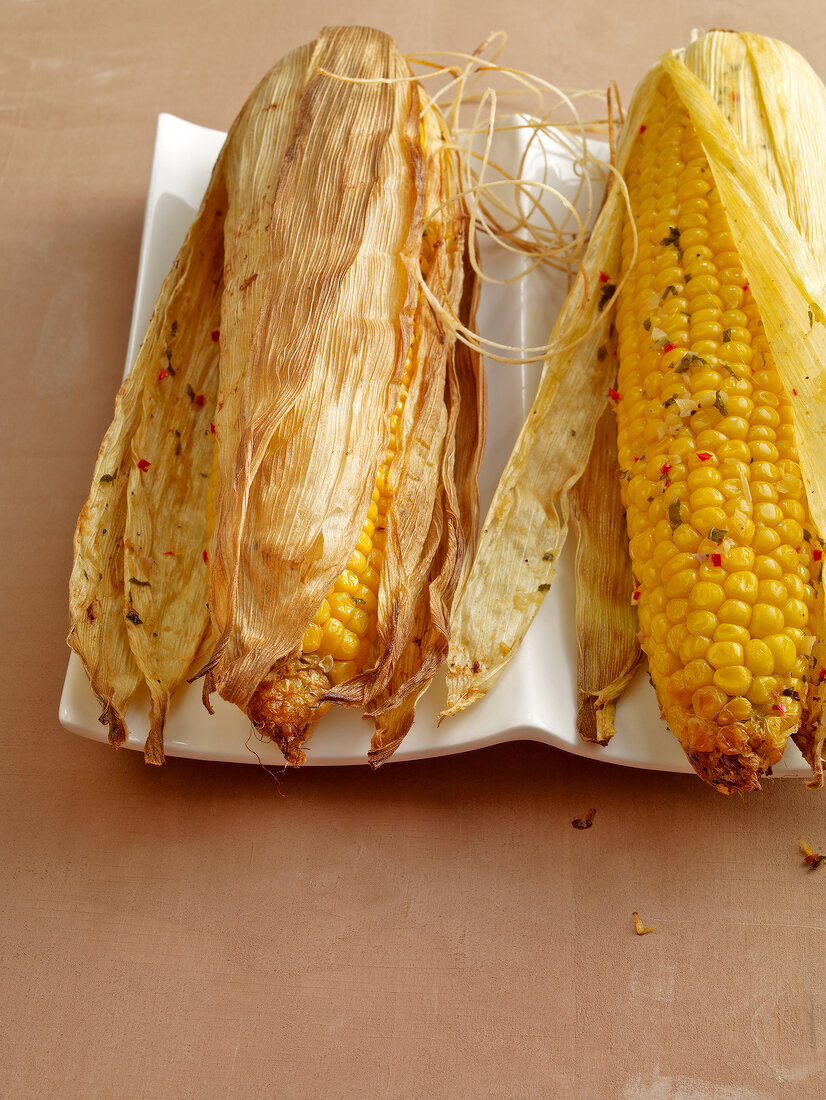 Close-up of grilled corn with lemon butter in serving dish