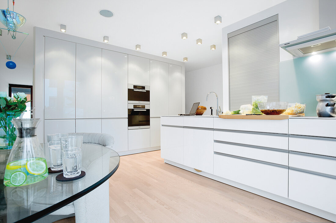 Interior of kitchen in white with dining area